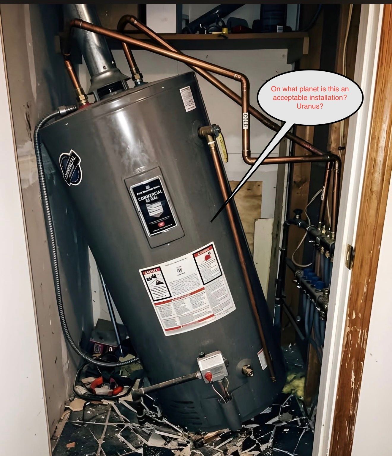 Water heater tipped over in a cramped utility closet, with exposed pipes and clutter on the floor.