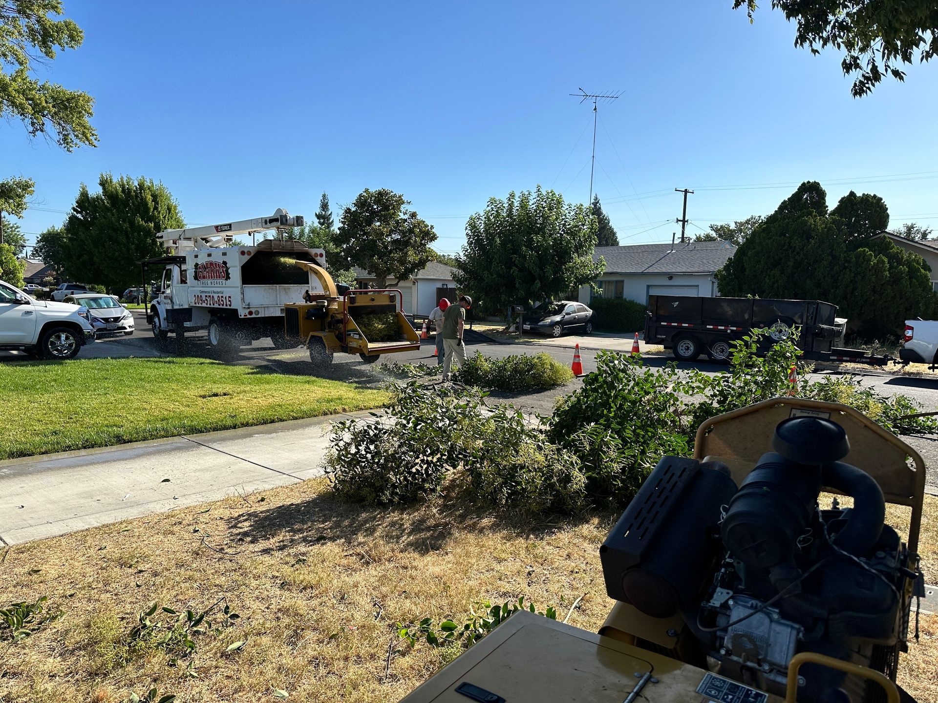 A tree stump grinder is sitting on the side of the road next to a truck.