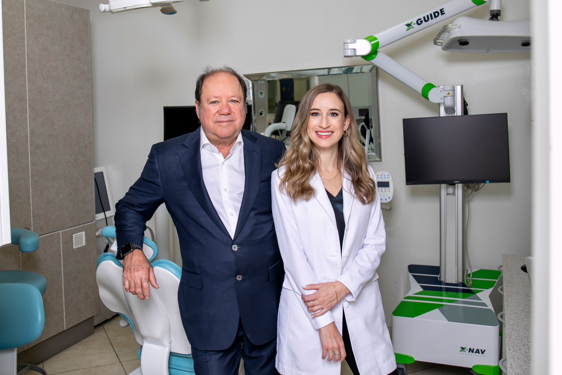A man and a woman are posing for a picture in a dental office.