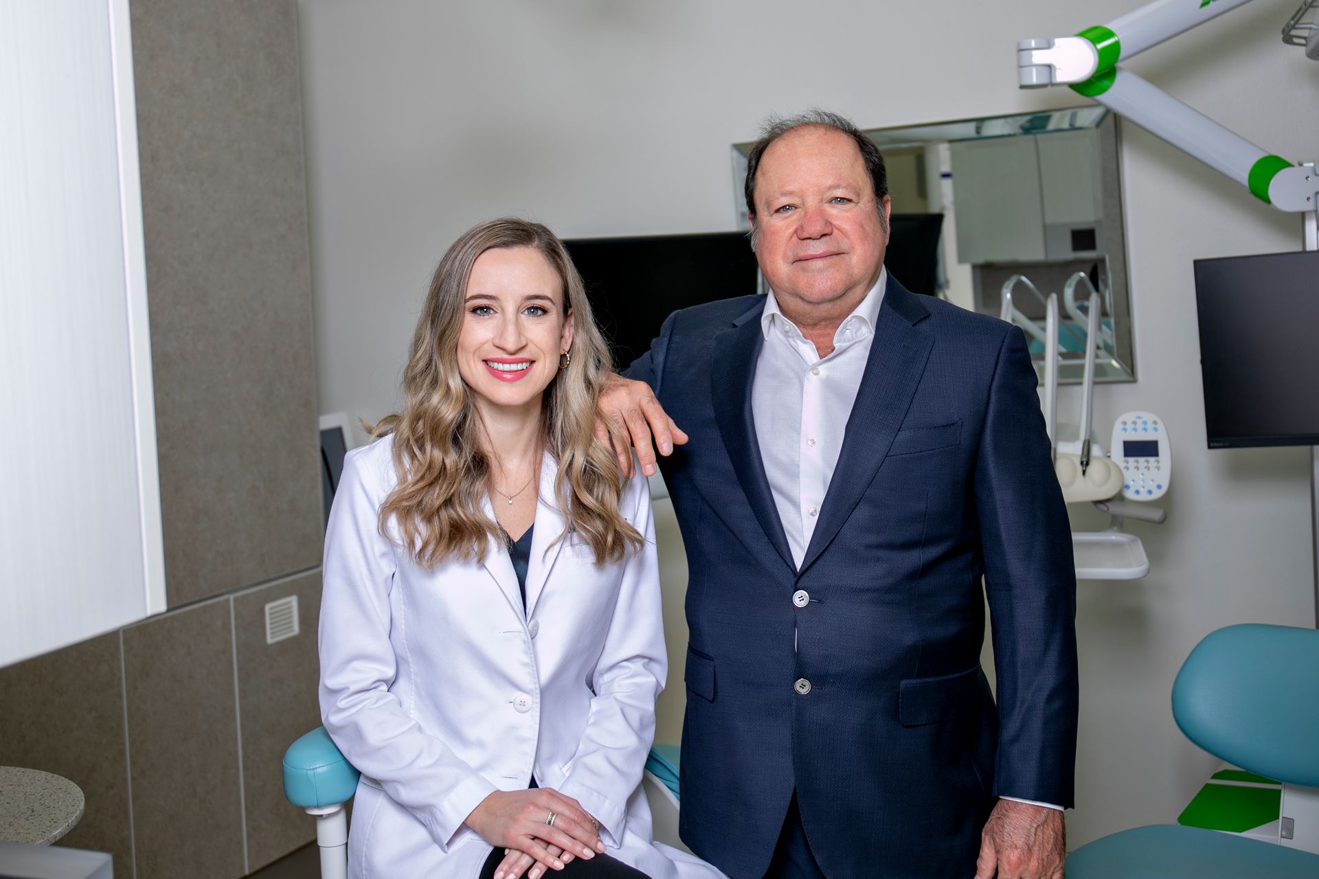 A man and a woman are posing for a picture in a dental office.