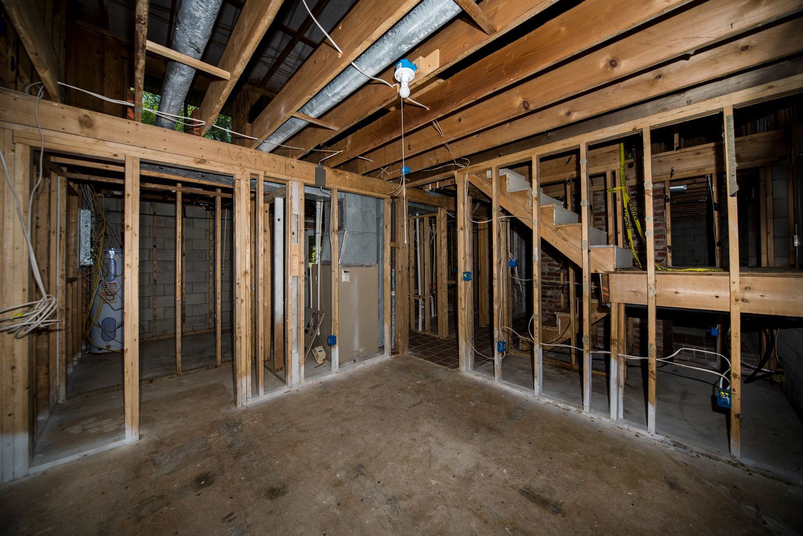 A basement under construction with wooden beams and a staircase.