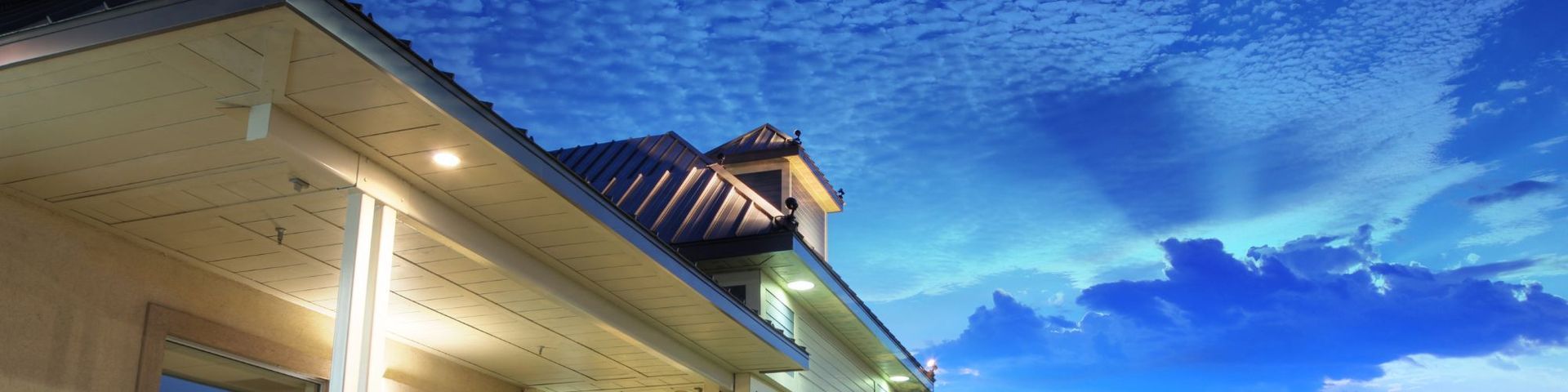 A building with a blue sky in the background is lit up at night.