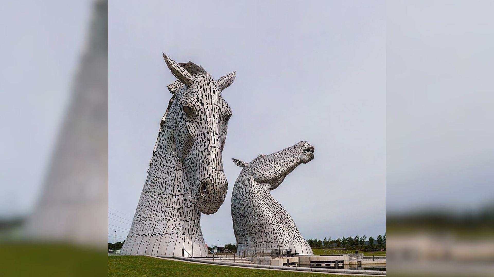 Two horse statues are standing next to each other in a field.