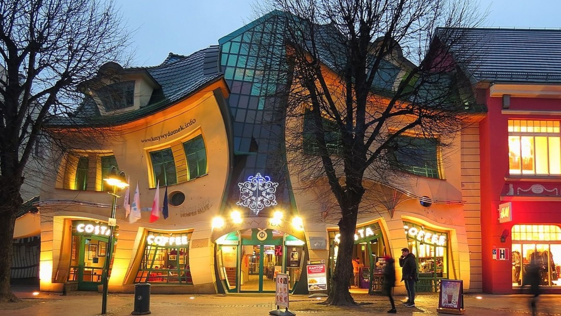 A building with a curved roof and a coffee shop in front of it
