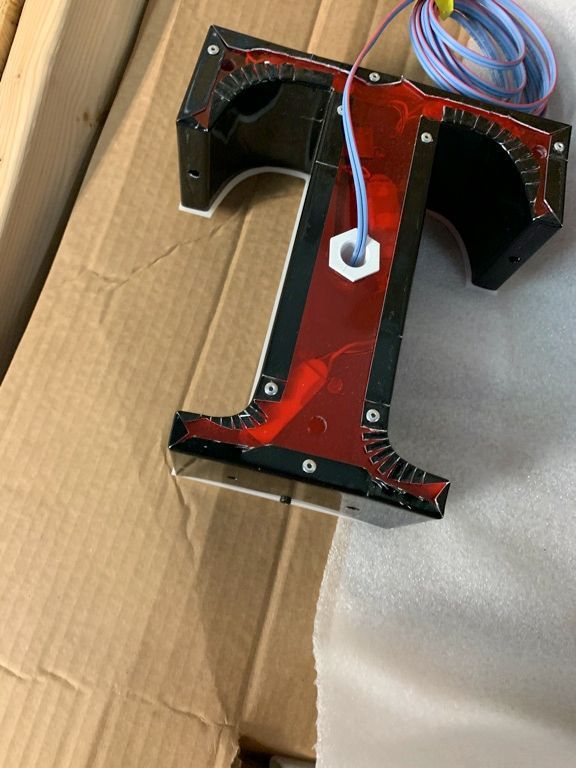 A letter t is sitting on top of a cardboard box