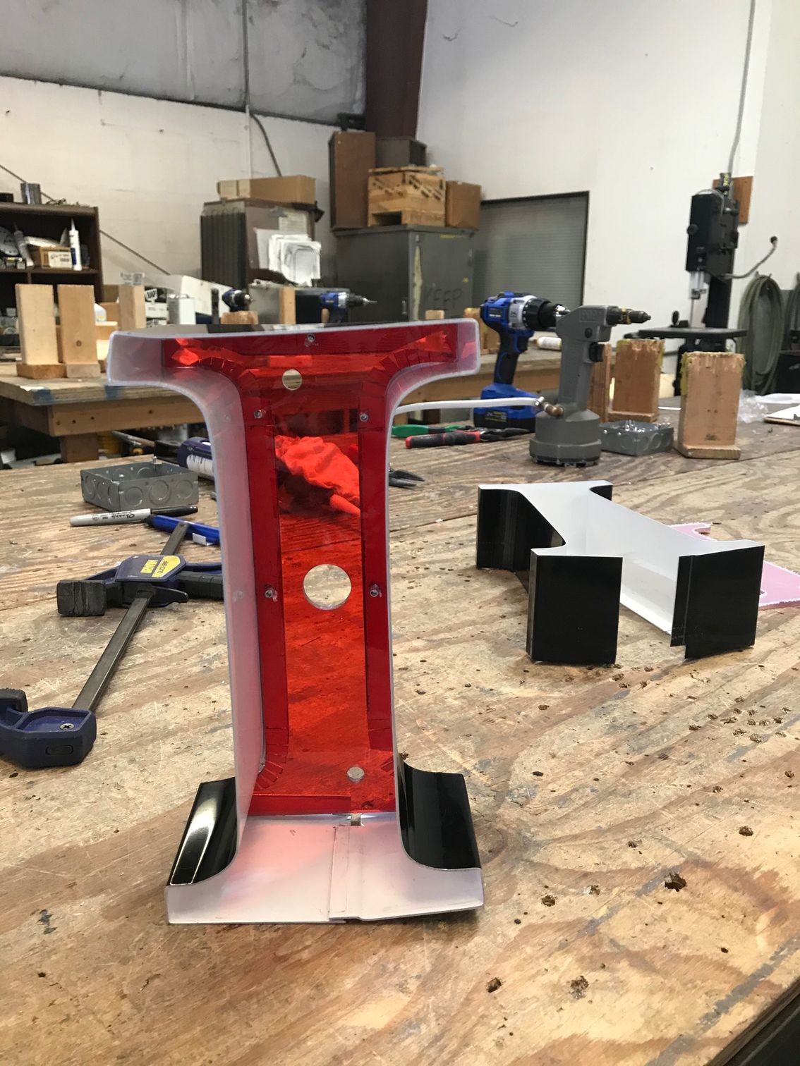 A red letter i is sitting on a wooden table.