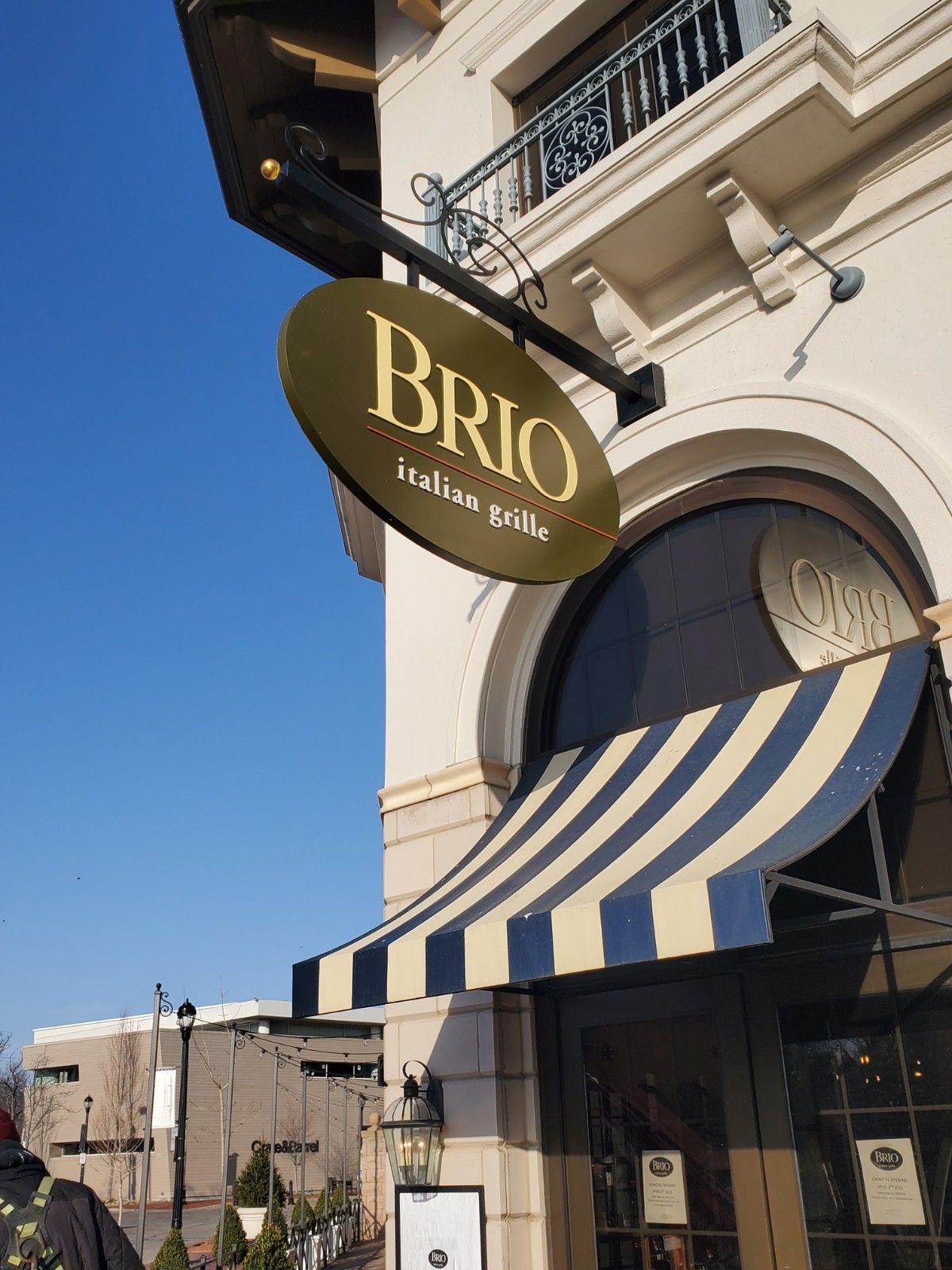 A brio sign hangs from the side of a building