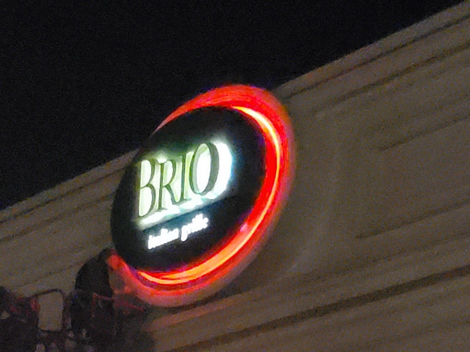 A brio sign is lit up at night