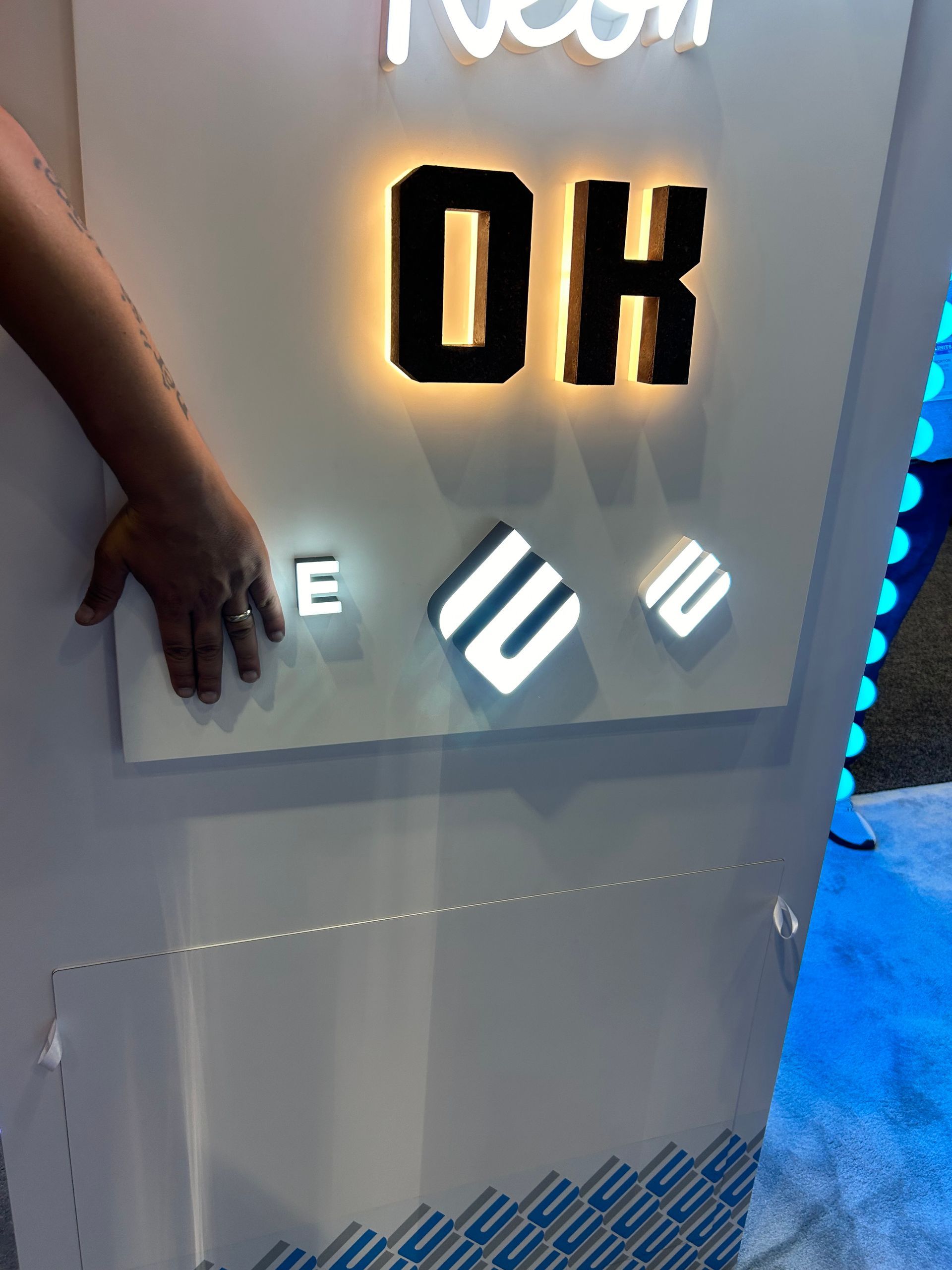 A person 's hand is reaching for a sign that says ok