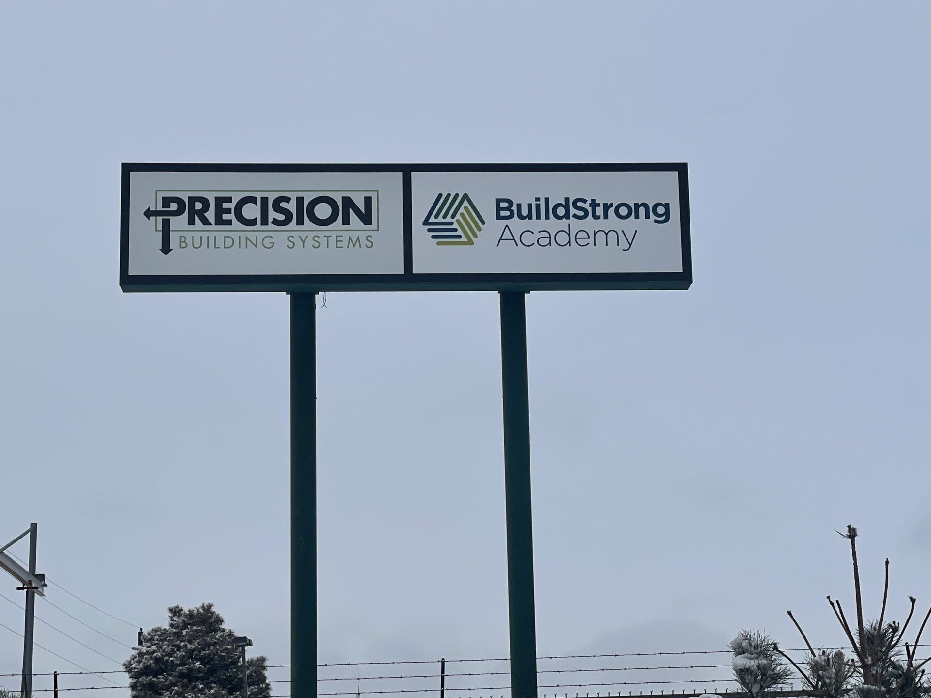 A billboard for precision and buildstrong academy
