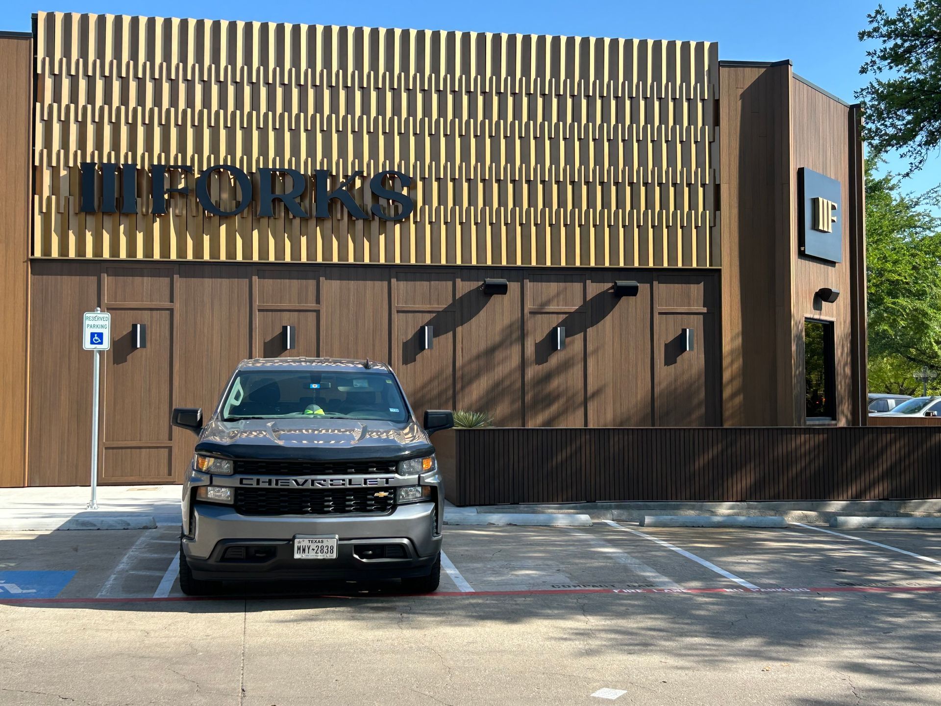 A car is parked in front of a building with the word office on it
