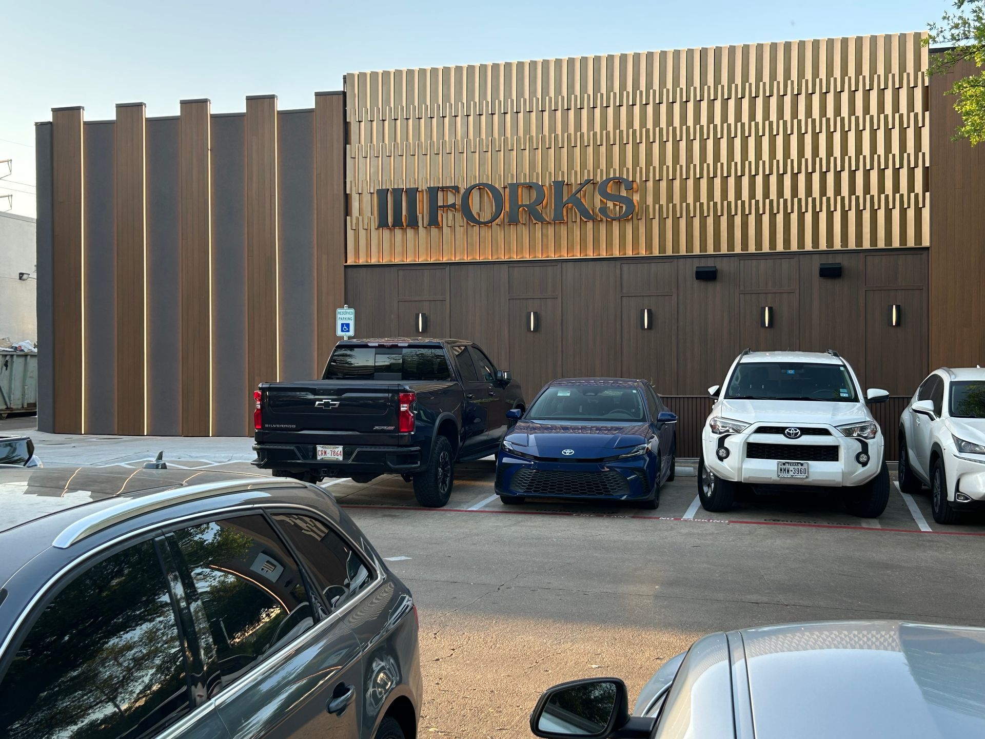 A row of cars are parked in front of a building.