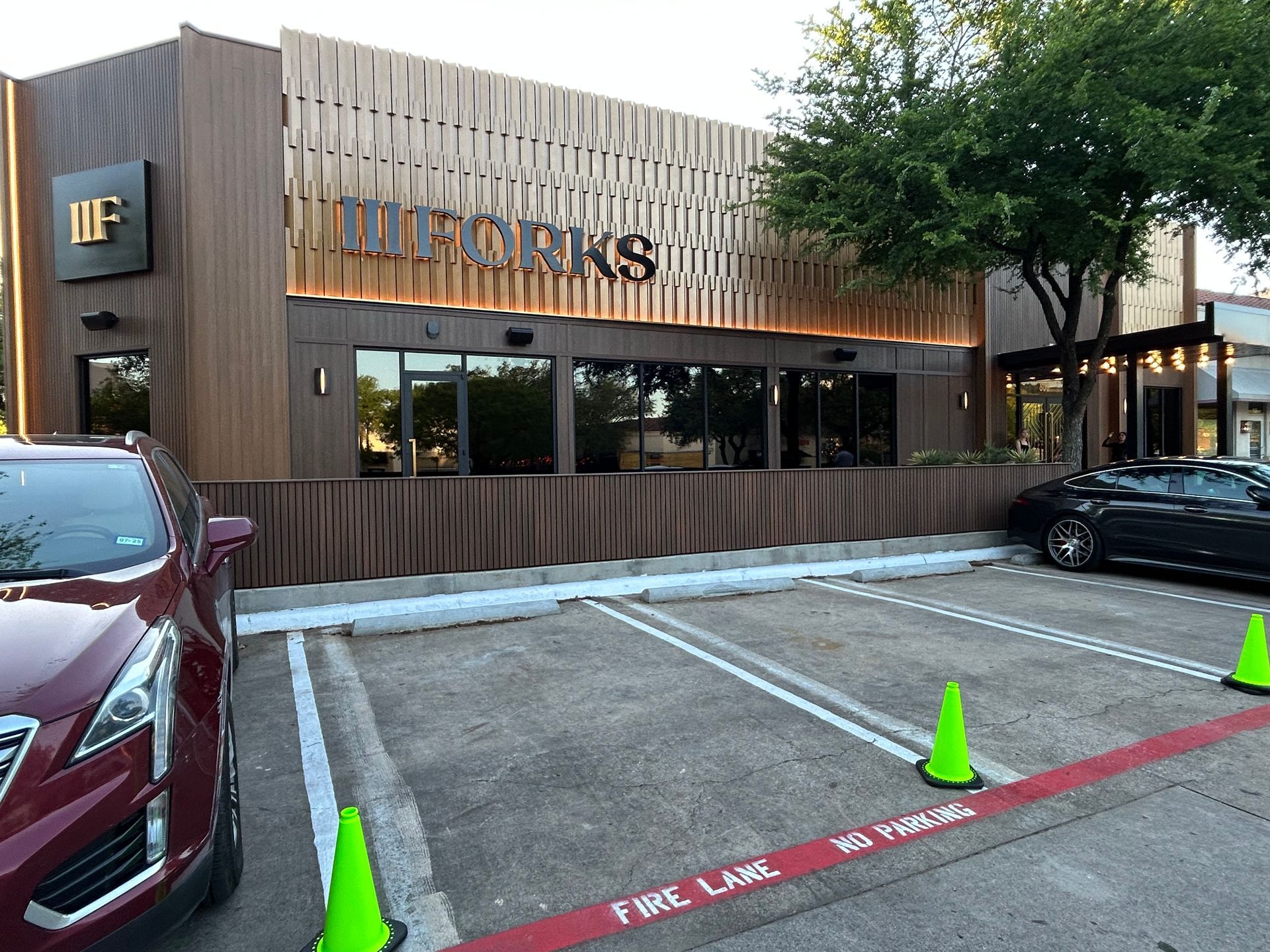 A red car is parked in front of a restaurant.