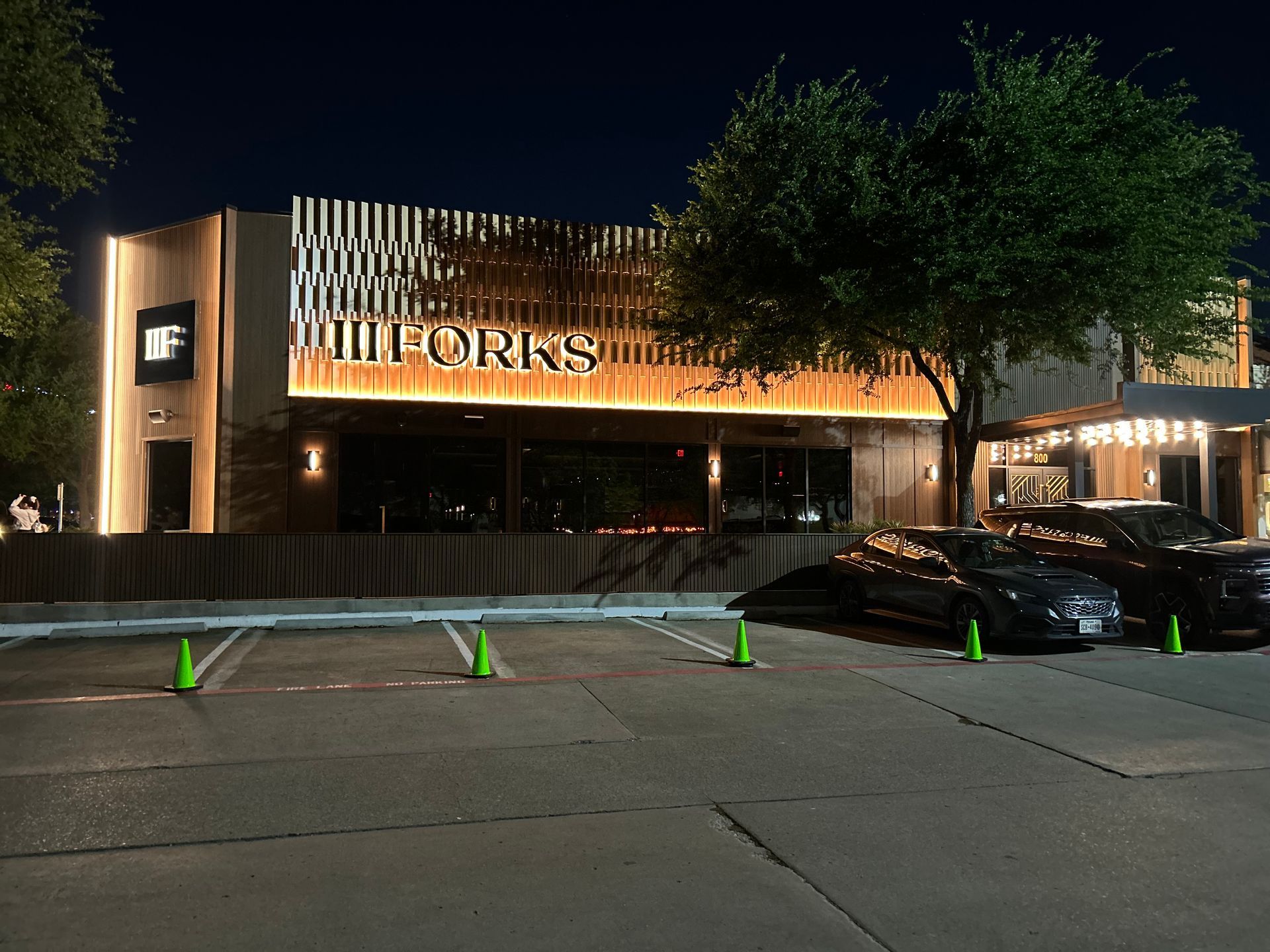 Cars are parked in front of a building that says will forks