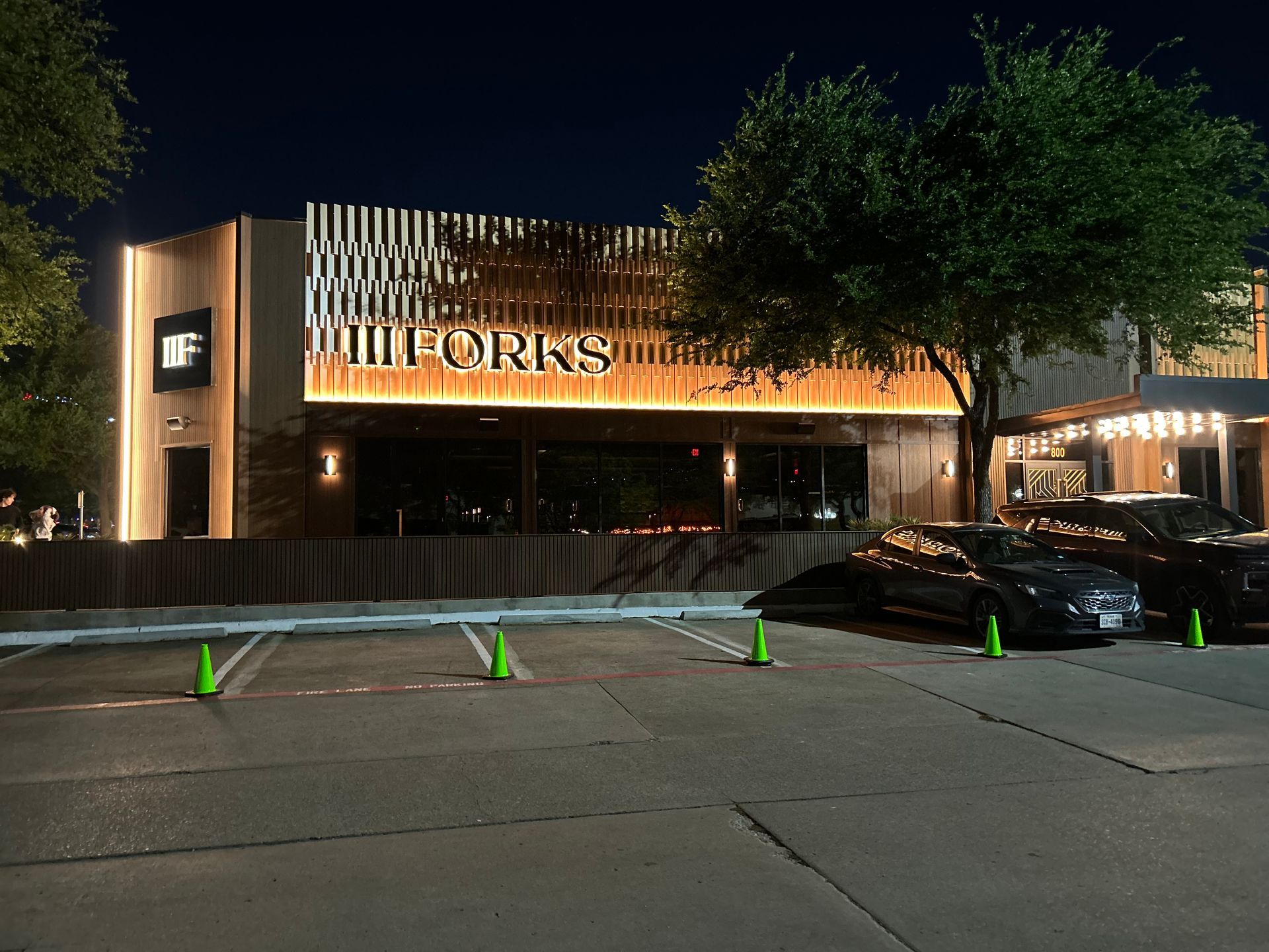 Cars are parked in front of a building that says uniforms
