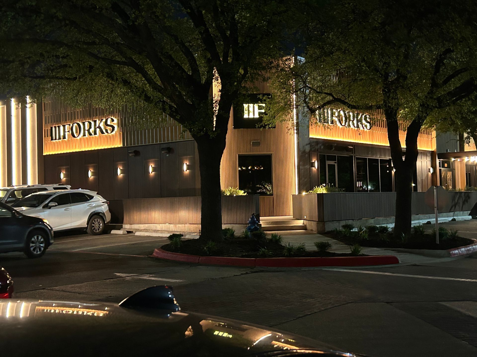 A restaurant with a lot of cars parked in front of it