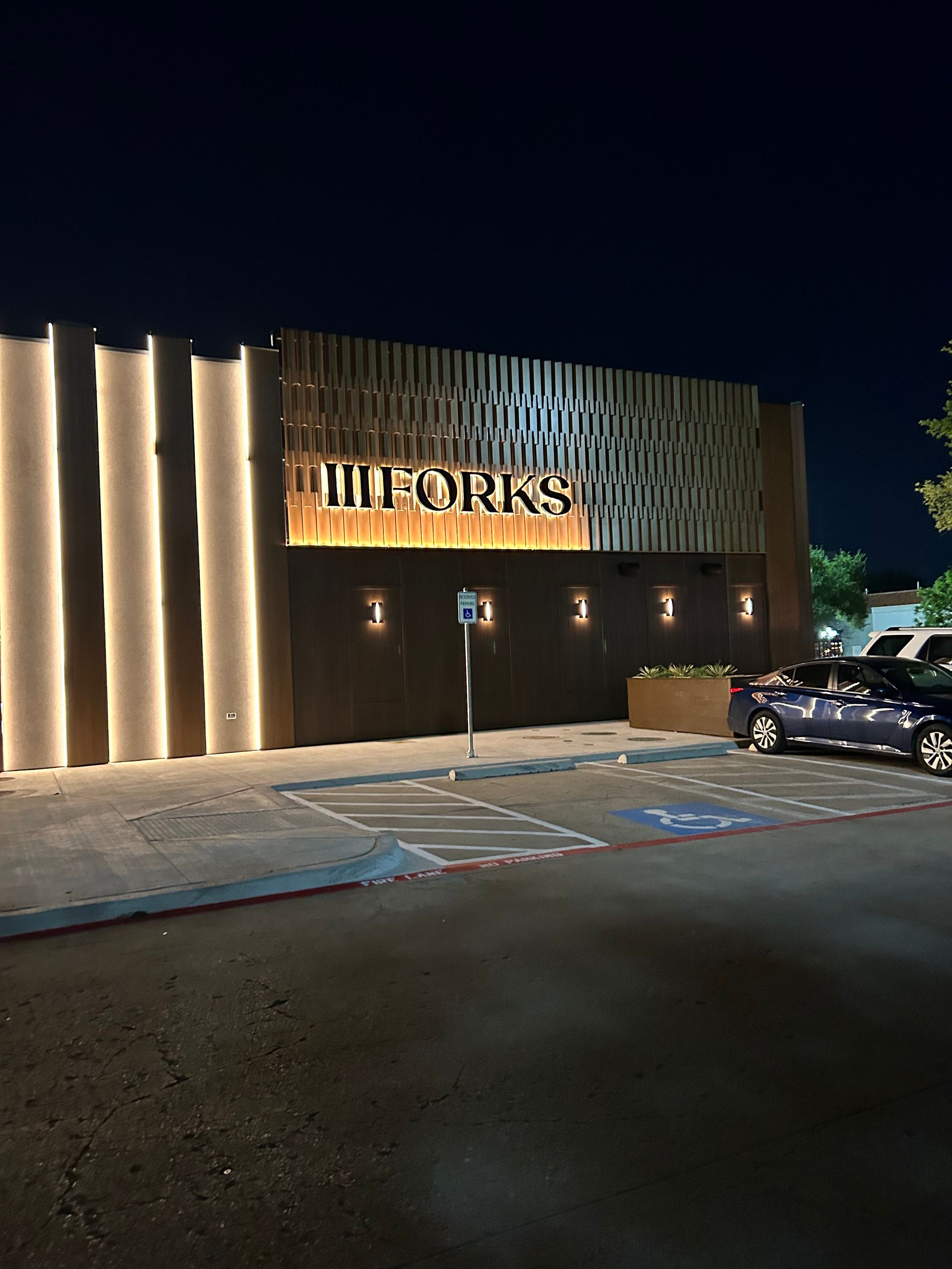 A car is parked in front of a building that says hill works