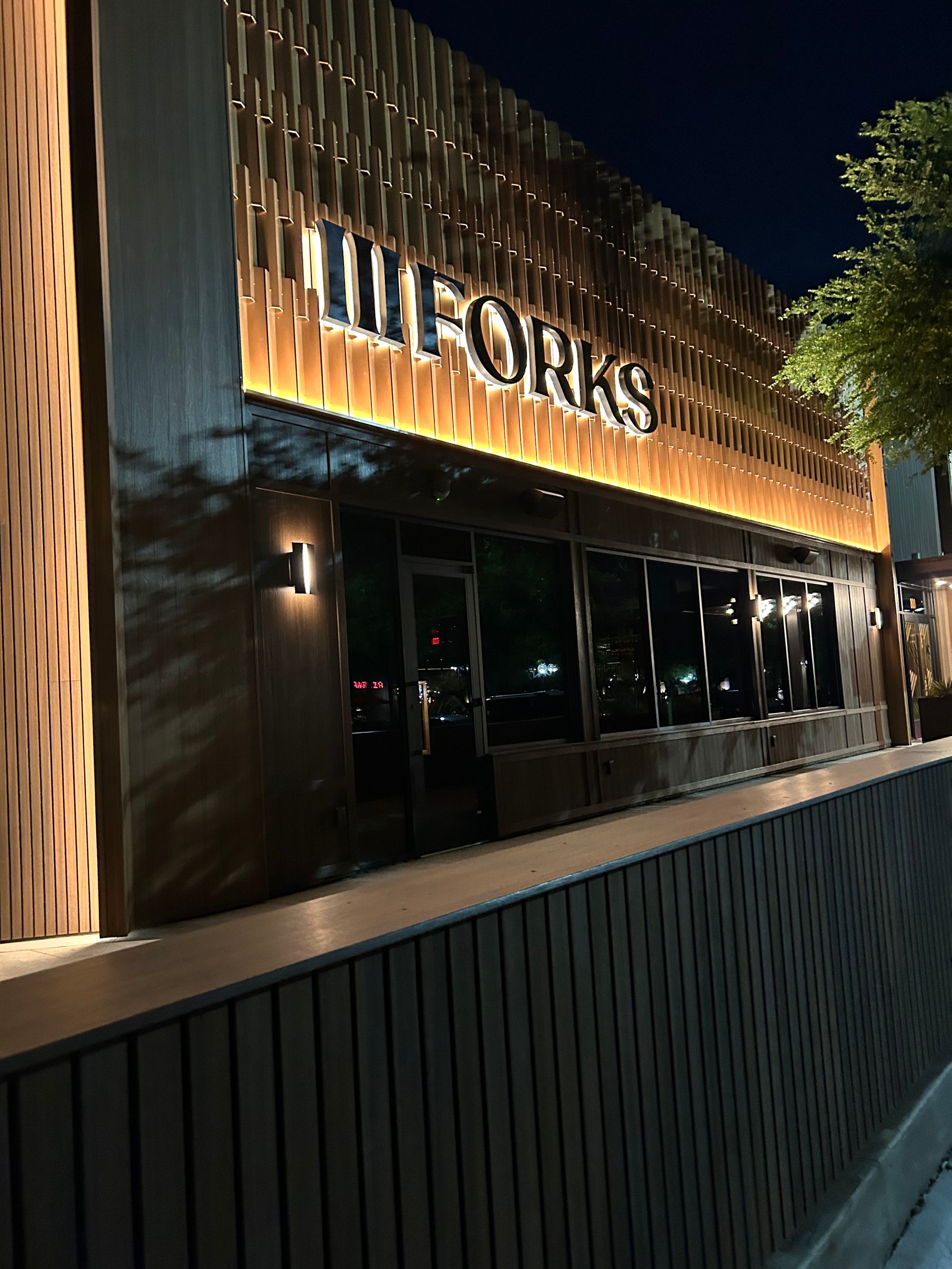 A building with the word forks on it is lit up at night.