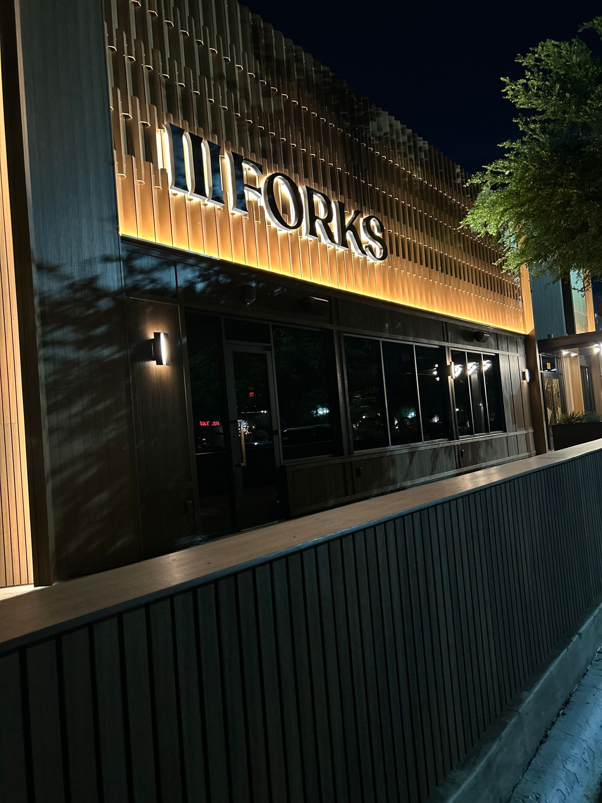 A building with the word forks on it is lit up at night.