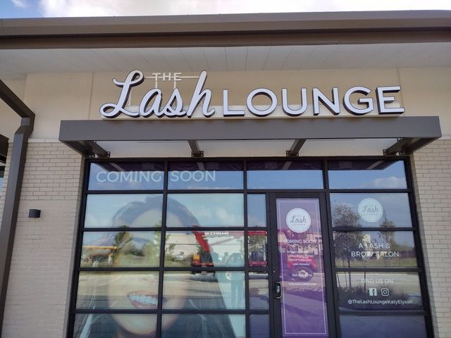 The lash lounge is coming soon and has a picture of a woman in the window