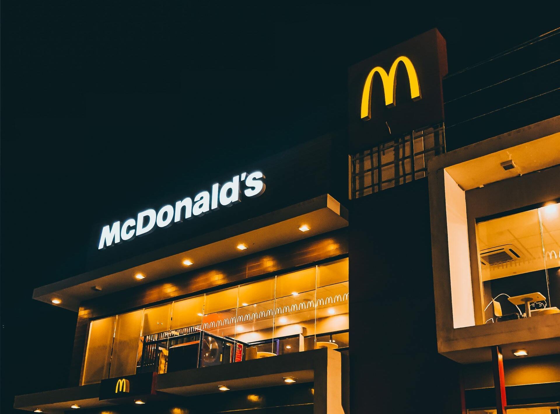 A mcdonald 's restaurant is lit up at night.