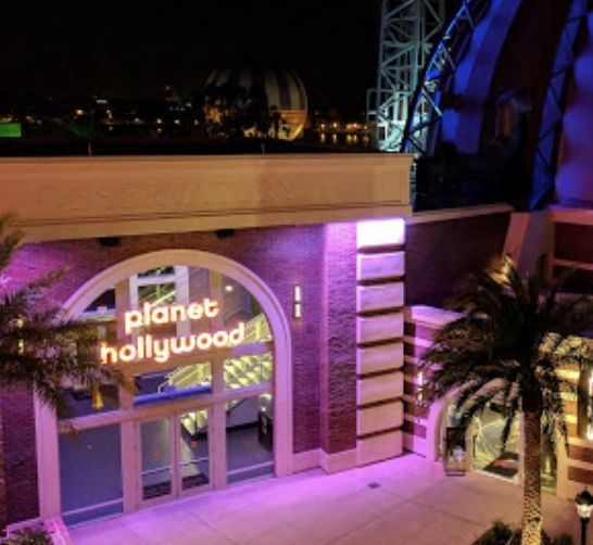 The planet hollywood building is lit up at night