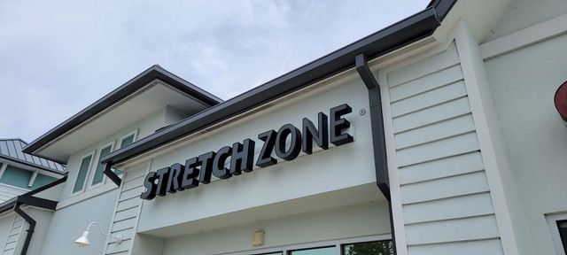 A stretch zone sign is on the side of a building.