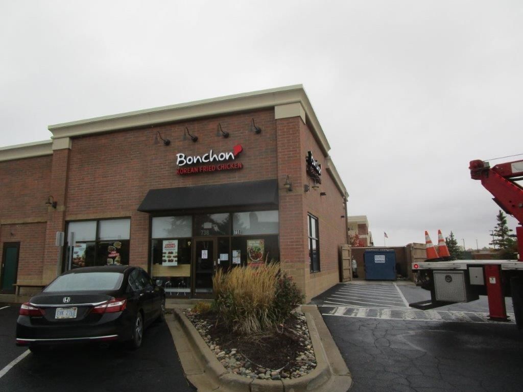A car is parked in front of a restaurant called benchman