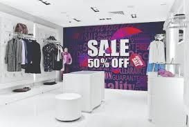 A clothing store with a sale sign on the wall.