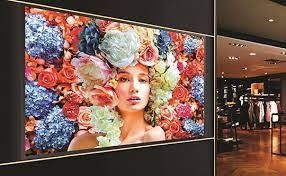 A woman with flowers in her hair is displayed on a wall in a store.