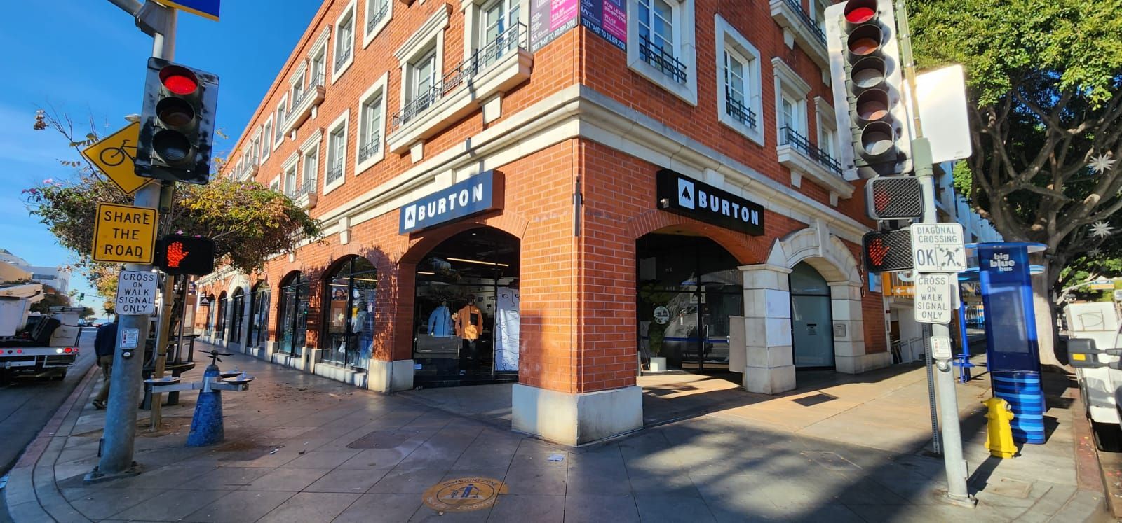 A domino 's pizza restaurant is located on the corner of a brick building.