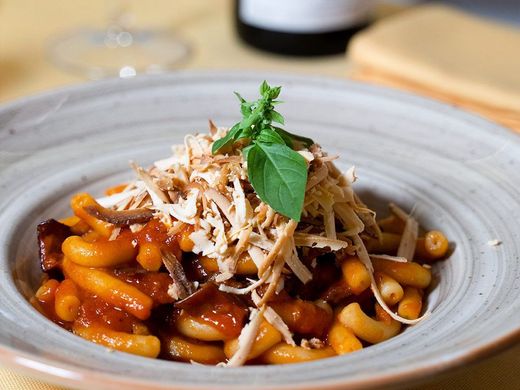 Un primo piano di un piatto di cibo con una bottiglia di vino sullo sfondo