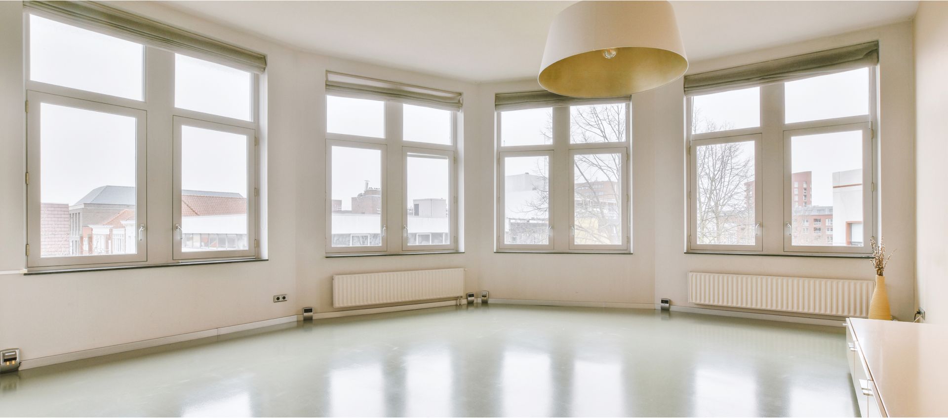 Bright, empty room with large windows, modern light fixture, and minimal decor, illustrating a clean space ideal for move-in or move-out cleaning services by Life Maid Easy in Emmaus, PA.