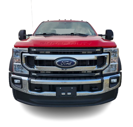 Red Ford Super Duty truck, front view. Chrome grille and bumper, black license plate area.