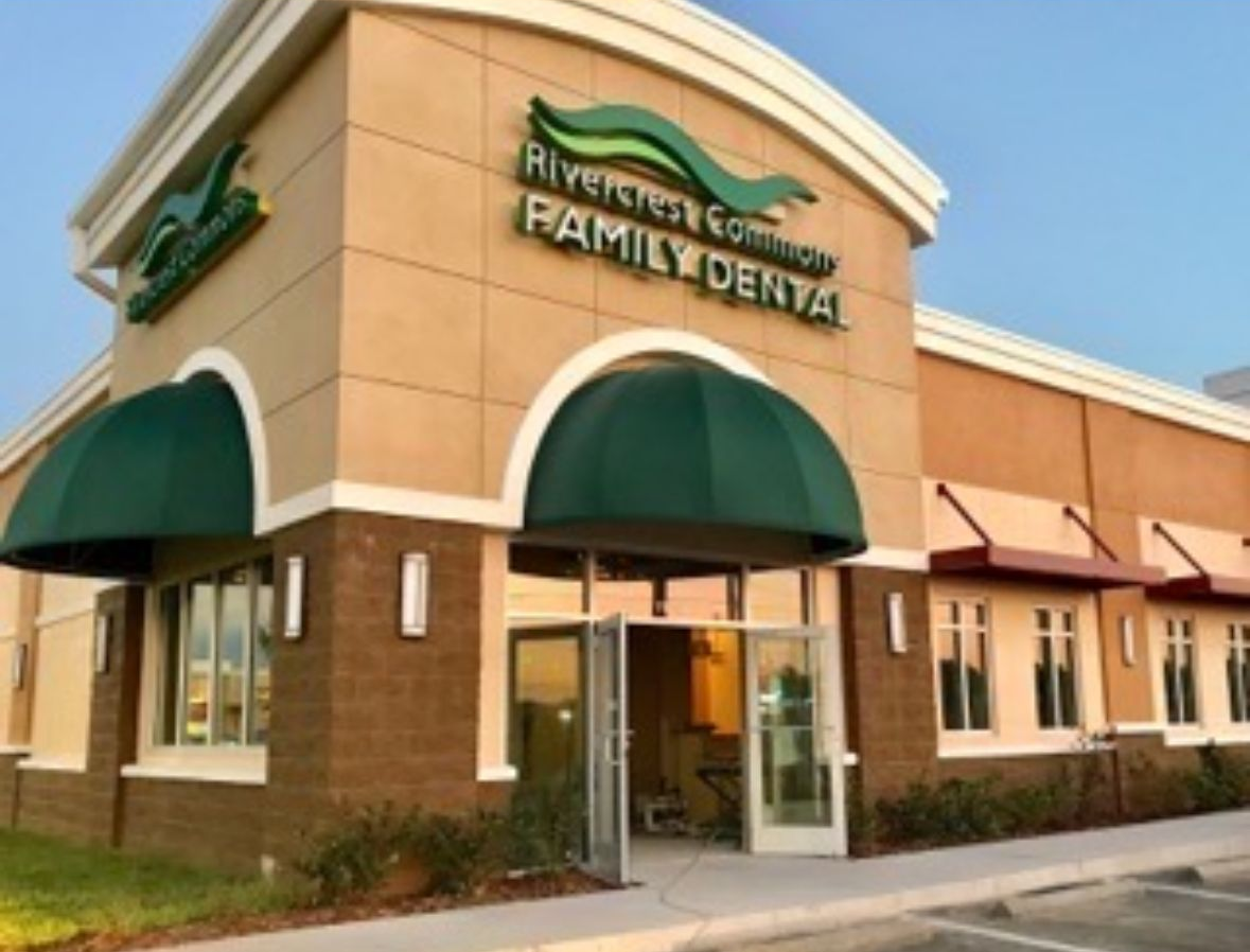 Exterior of Rivercrest Commons Family Dental office with green accents and awnings.