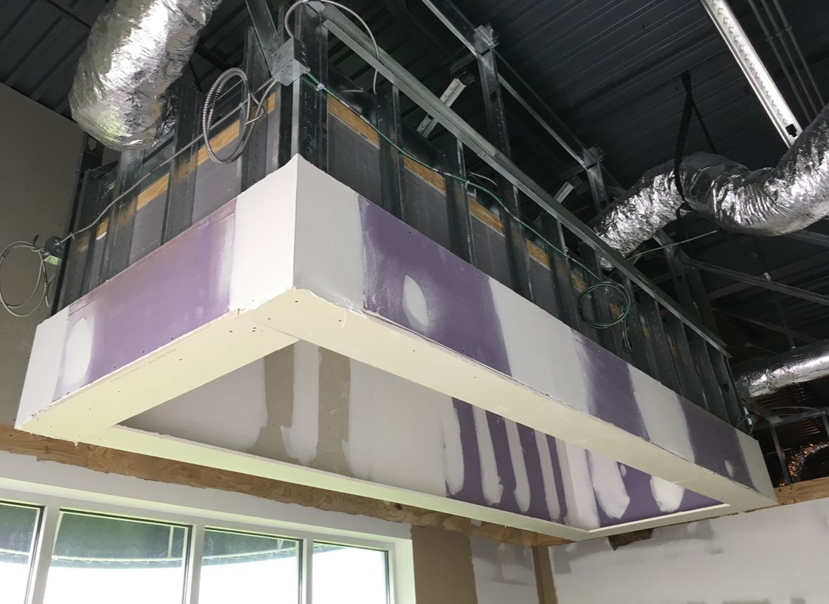 Ceiling construction with ductwork, drywall, and unfinished framing in an interior space.