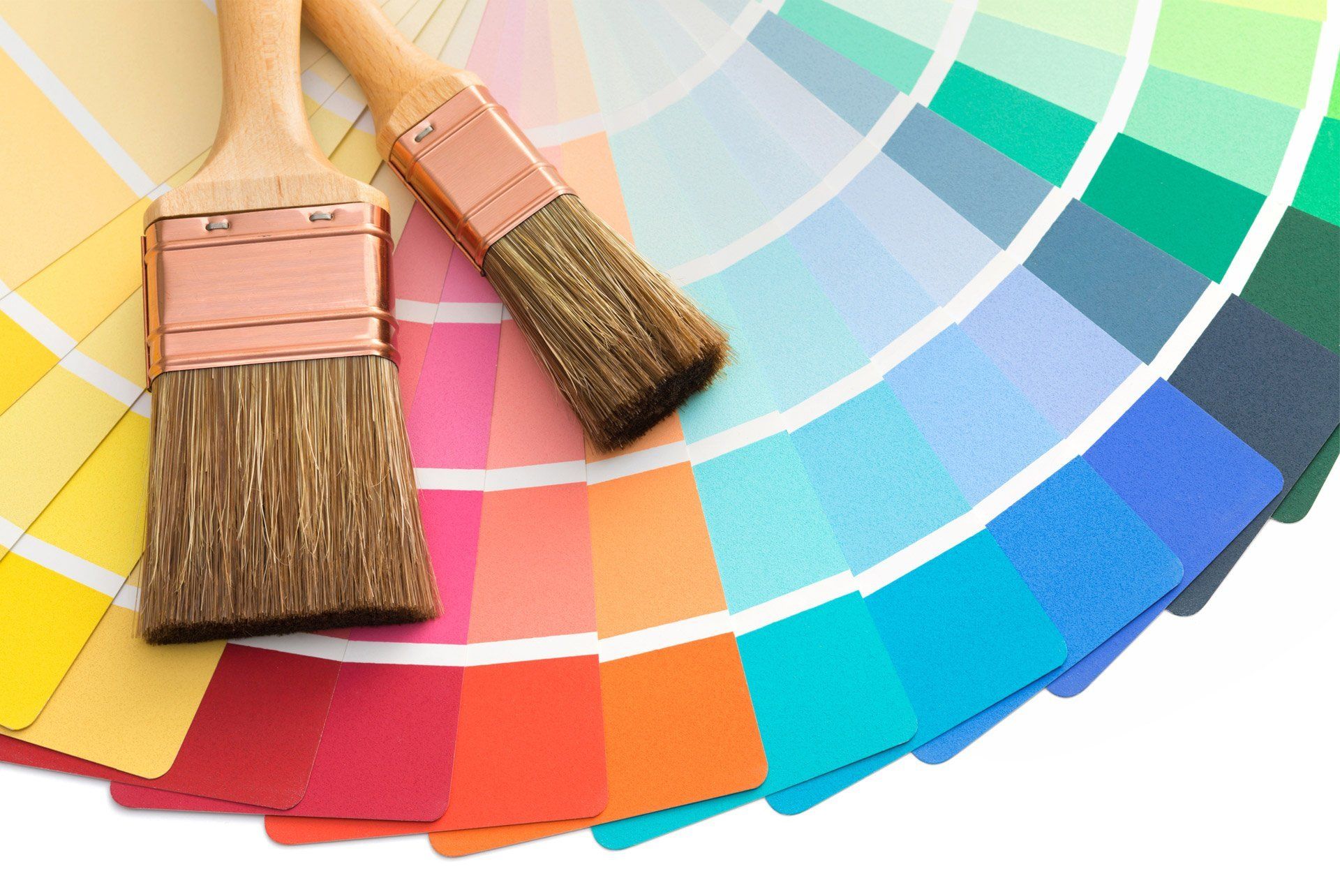 Two paint brushes are sitting on top of a color wheel.