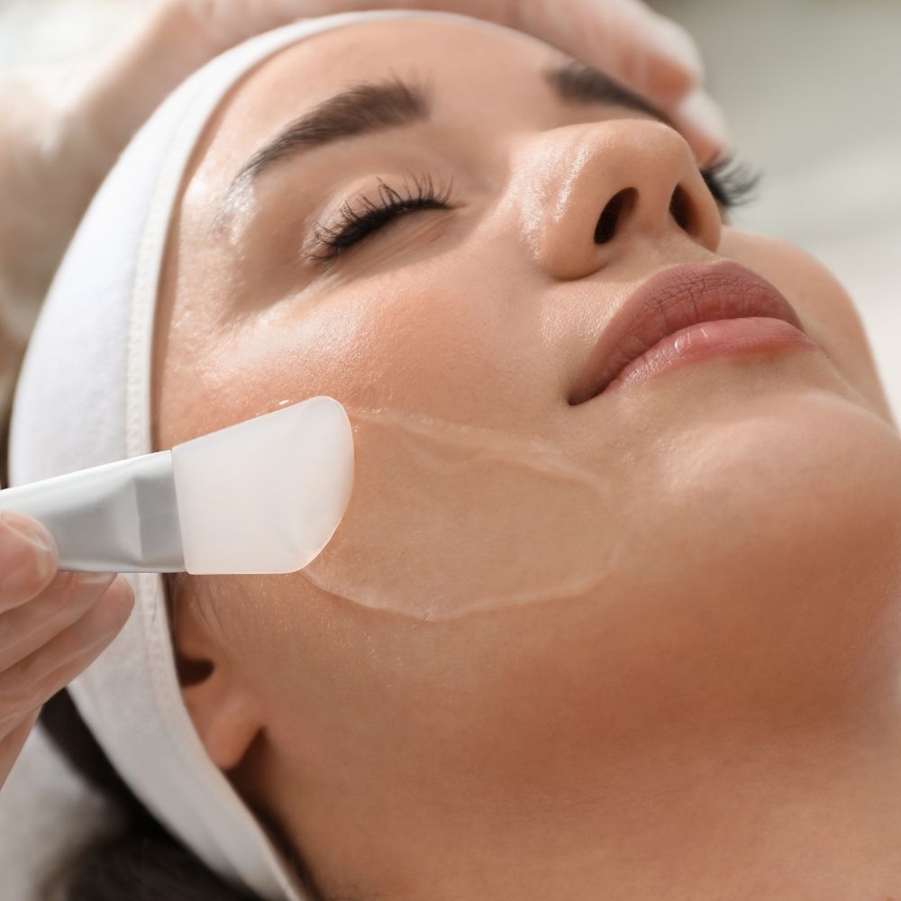 A treatment mask being lifted away to reveal fresh skin underneath