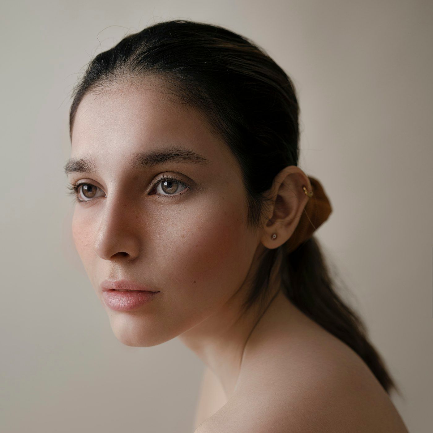 A composed studio portrait with smooth, healthy skin