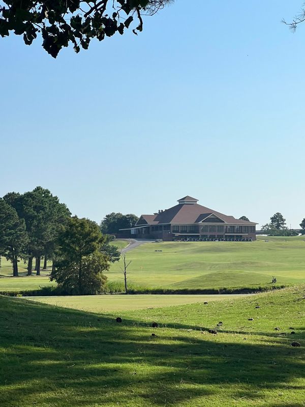 A golf course with a large building in the background