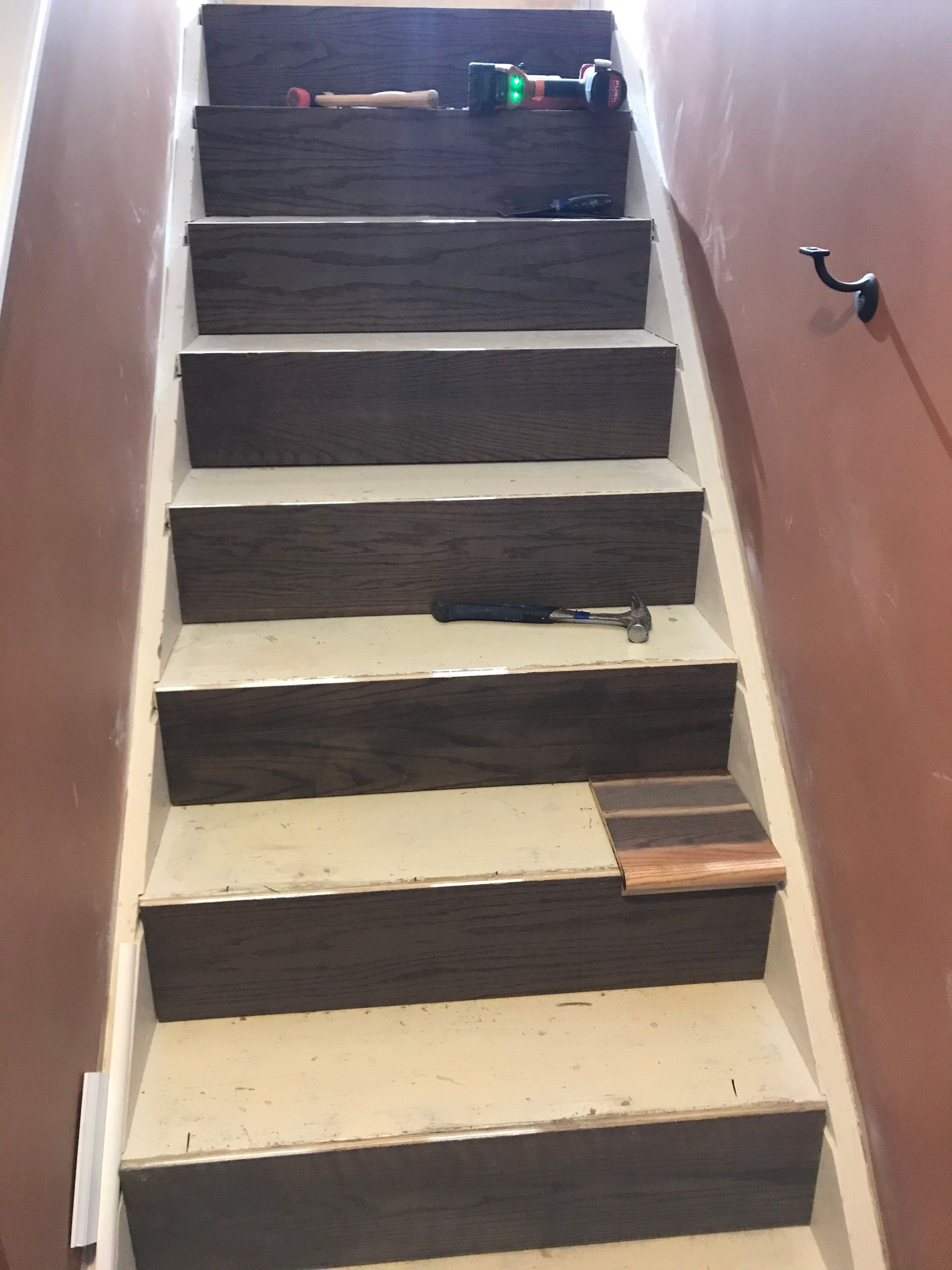 Staircase with wooden steps being renovated; tools on top.