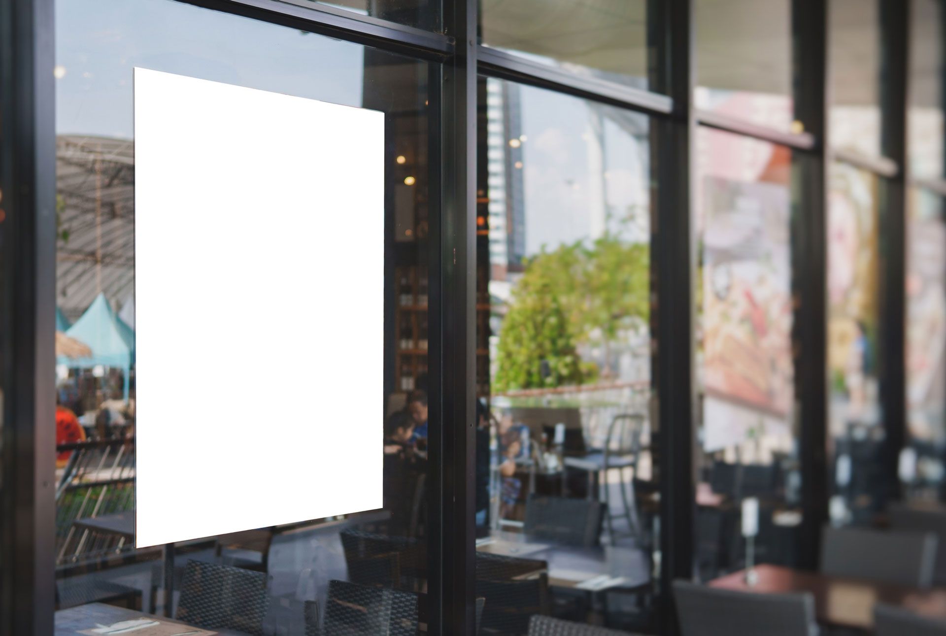 A white sign is hanging on a window in a restaurant.