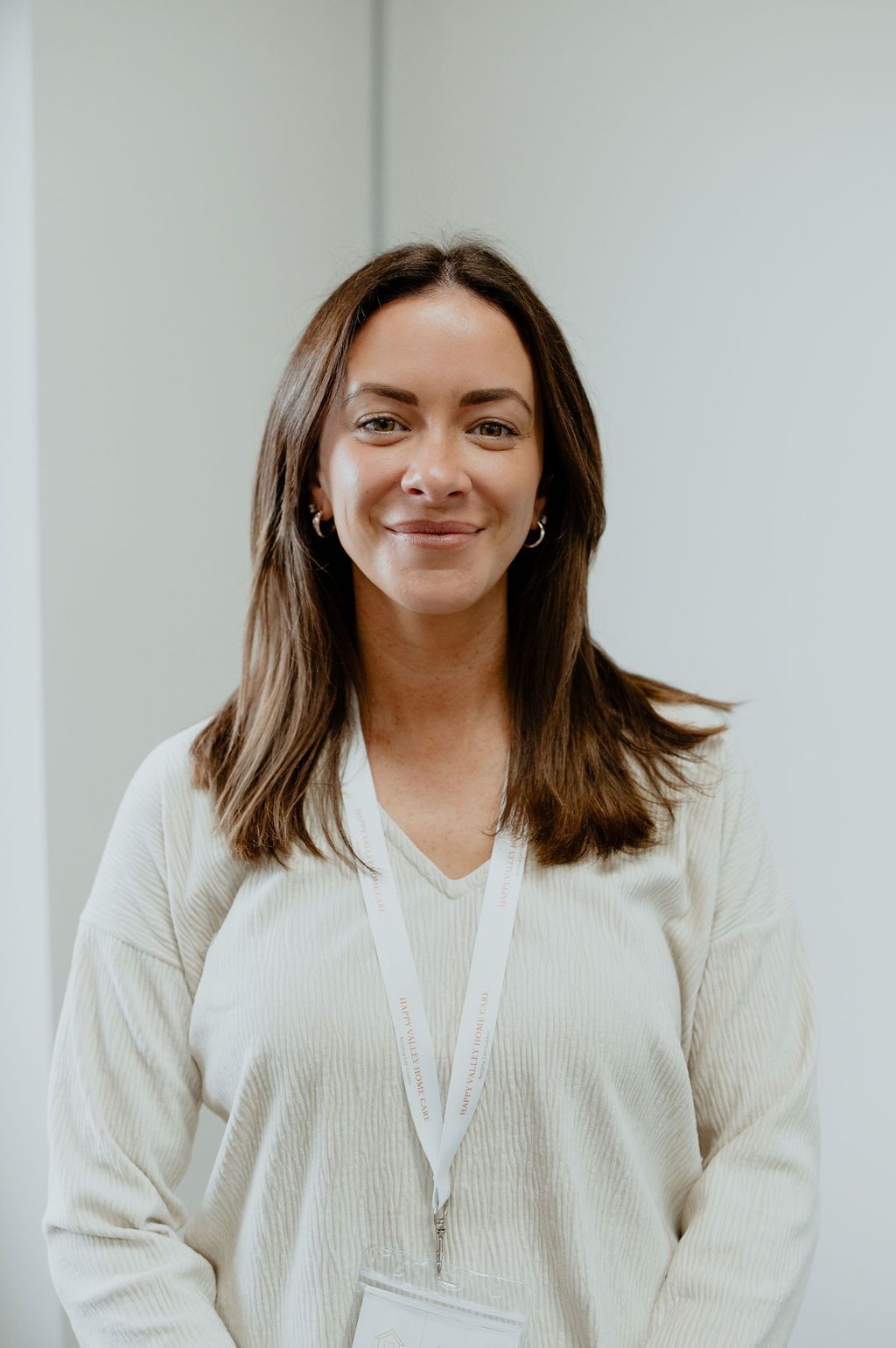 Portrait of a smiling woman in a white blouse against a plain light background