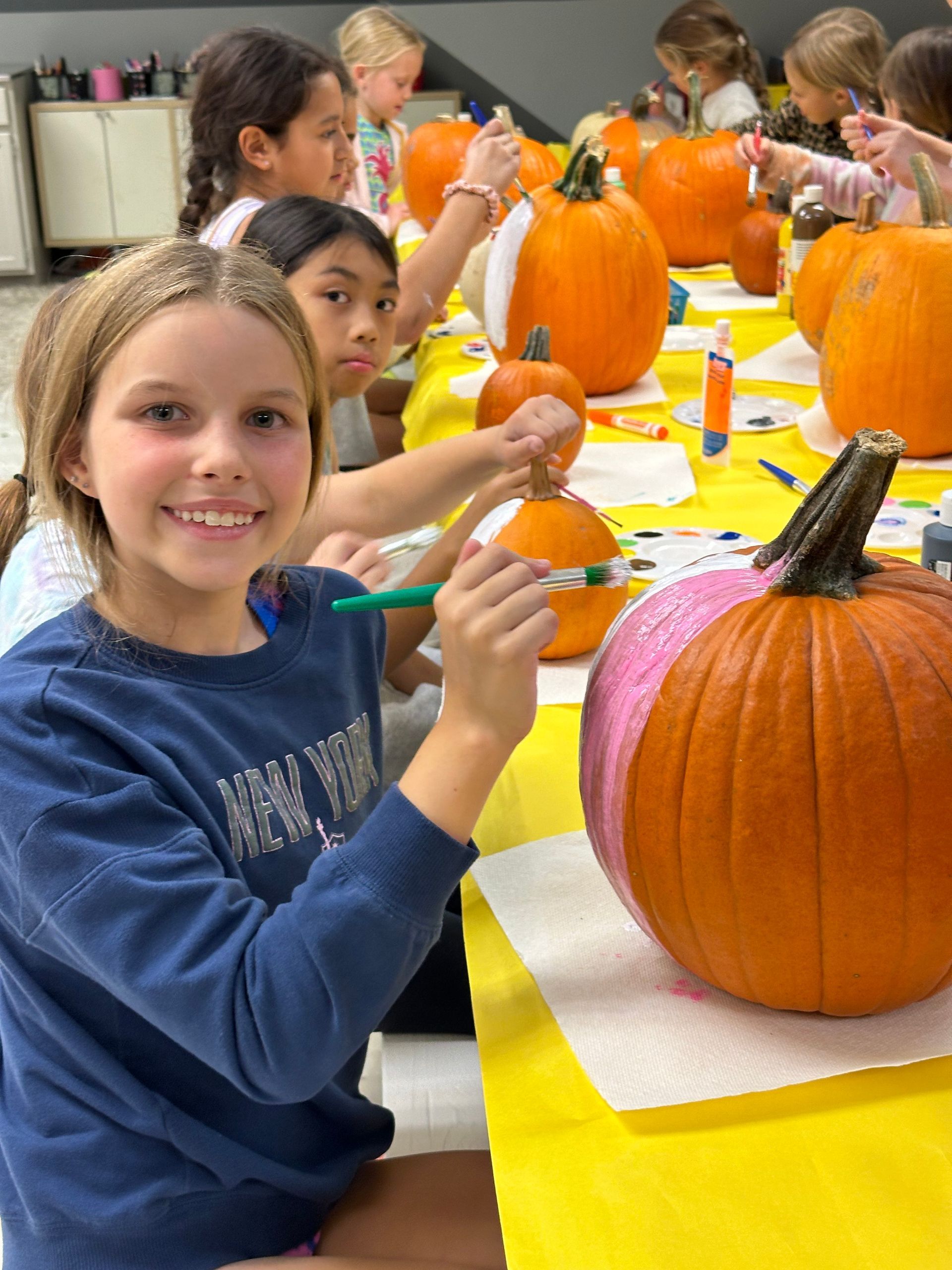 girl celebrating halloween with pumpkin painting