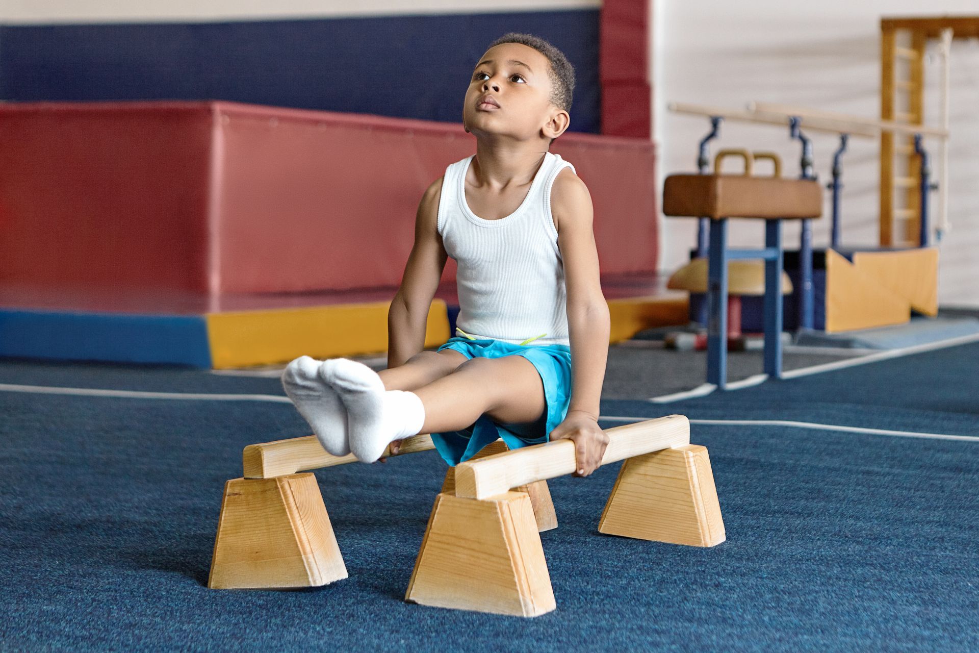 young boy on pbar trainer