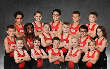 Gymnastics boys team in red and black uniforms posing for a group photo; 