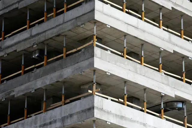 A building under construction with a lot of balconies and railings