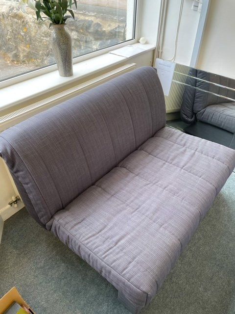 A couch is sitting in front of a window in a living room