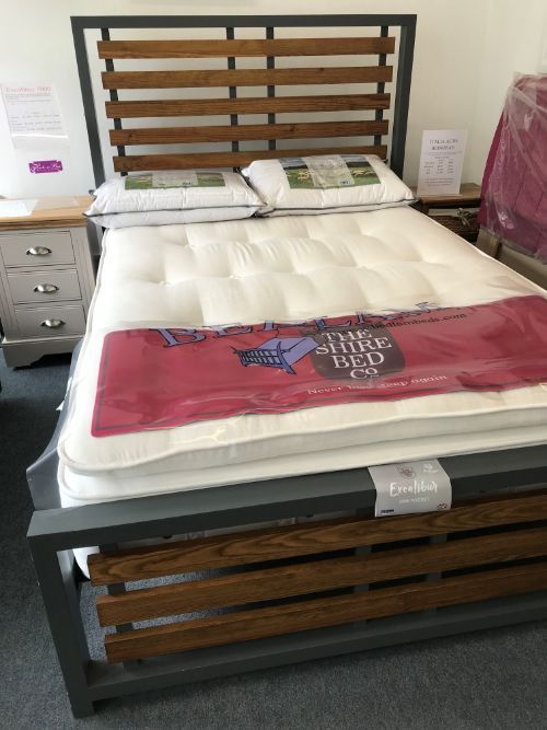 A bed with a mattress on it and a wooden headboard