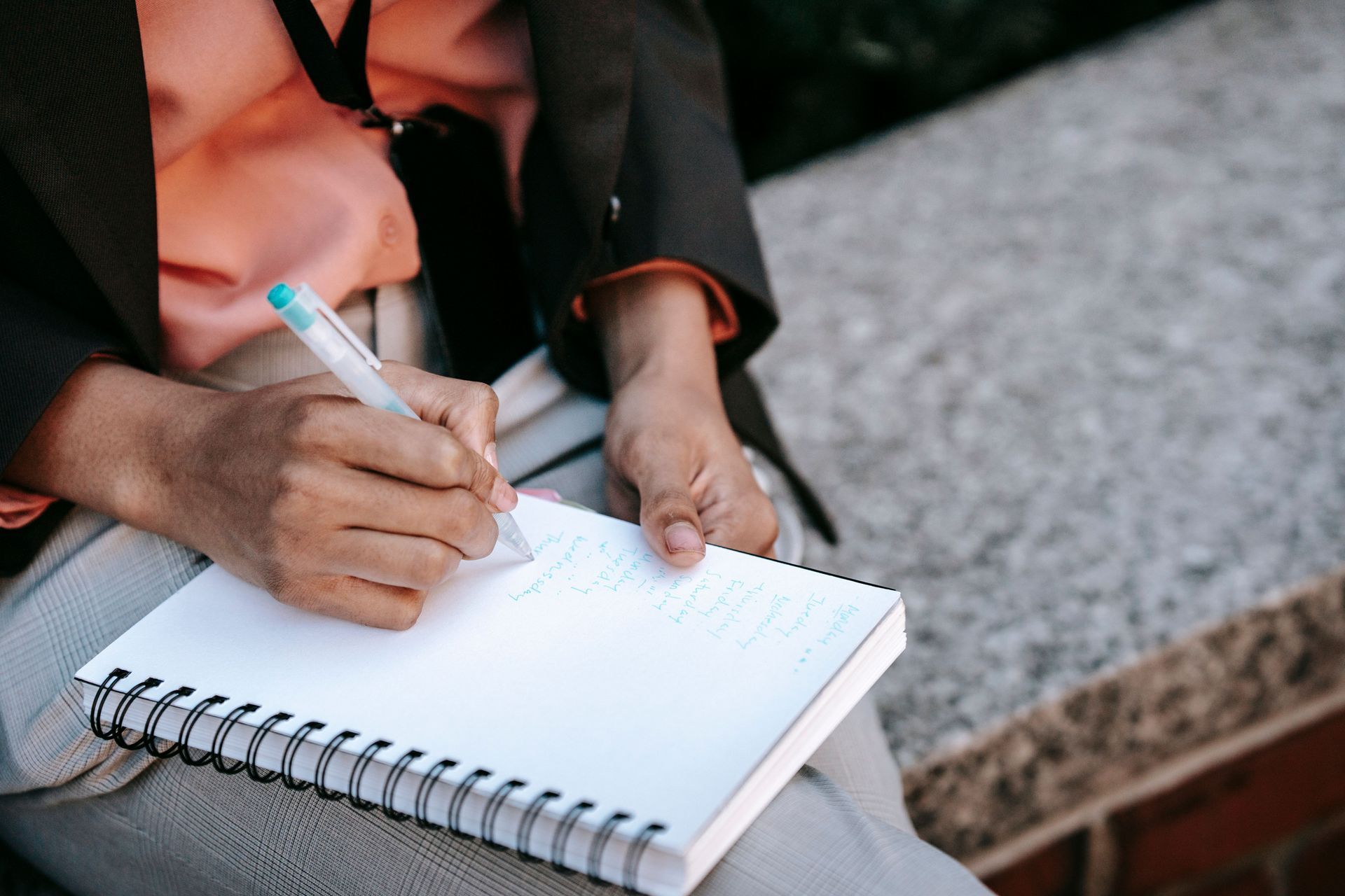 A person writing a caregiving schedule in a notebook to help manage the mental load of dementia care.